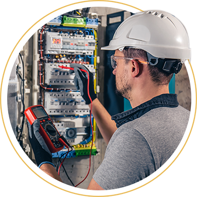 Image shows person working on a circuit board with a hard hat on.