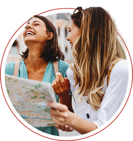 two women smiling looking at a map