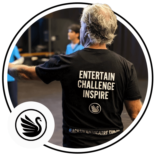 Image shows someone with their back to the camera wearing a tshirt that says Entertain, Challenge and Inspire