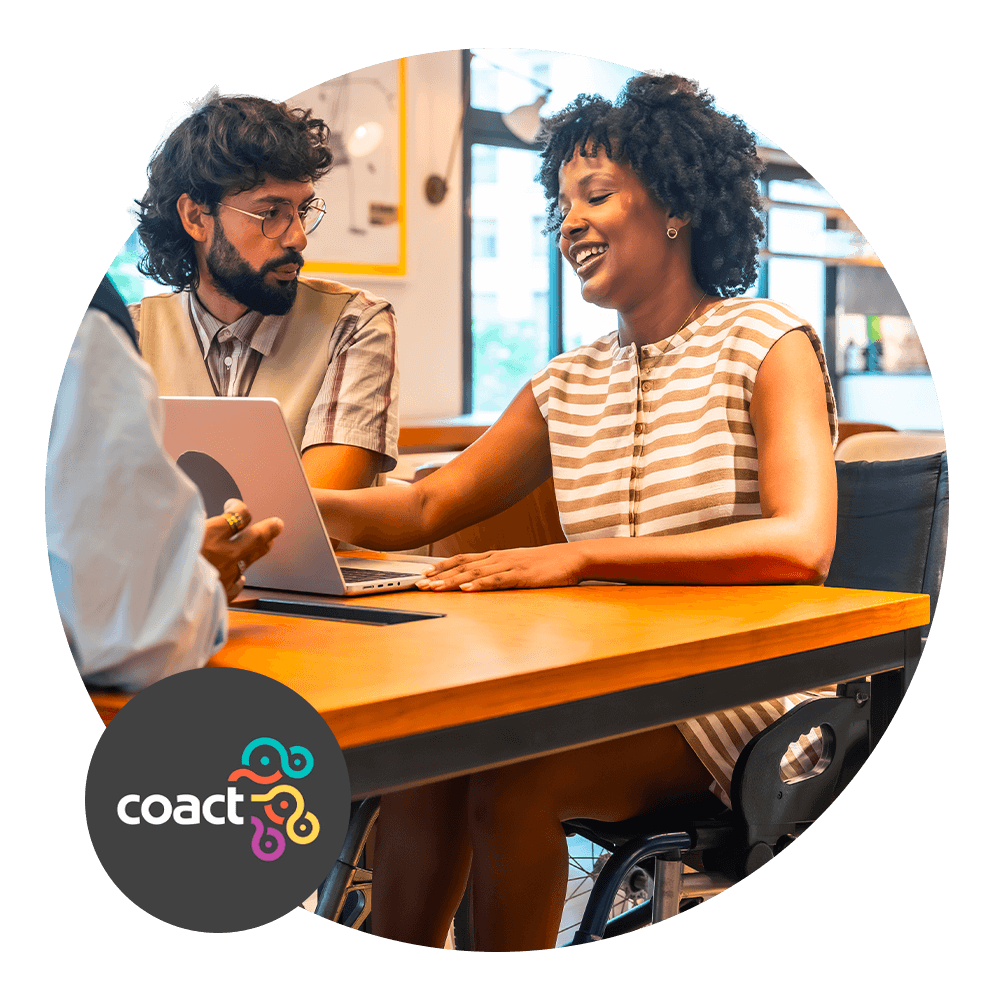 2 people working on a laptop at a desk.