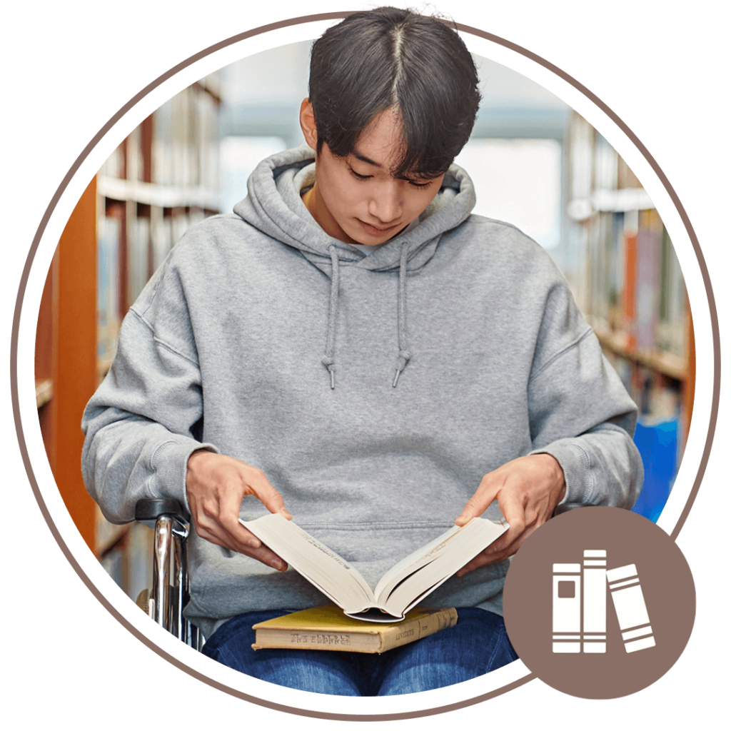 man in a library reading a book while sitting down