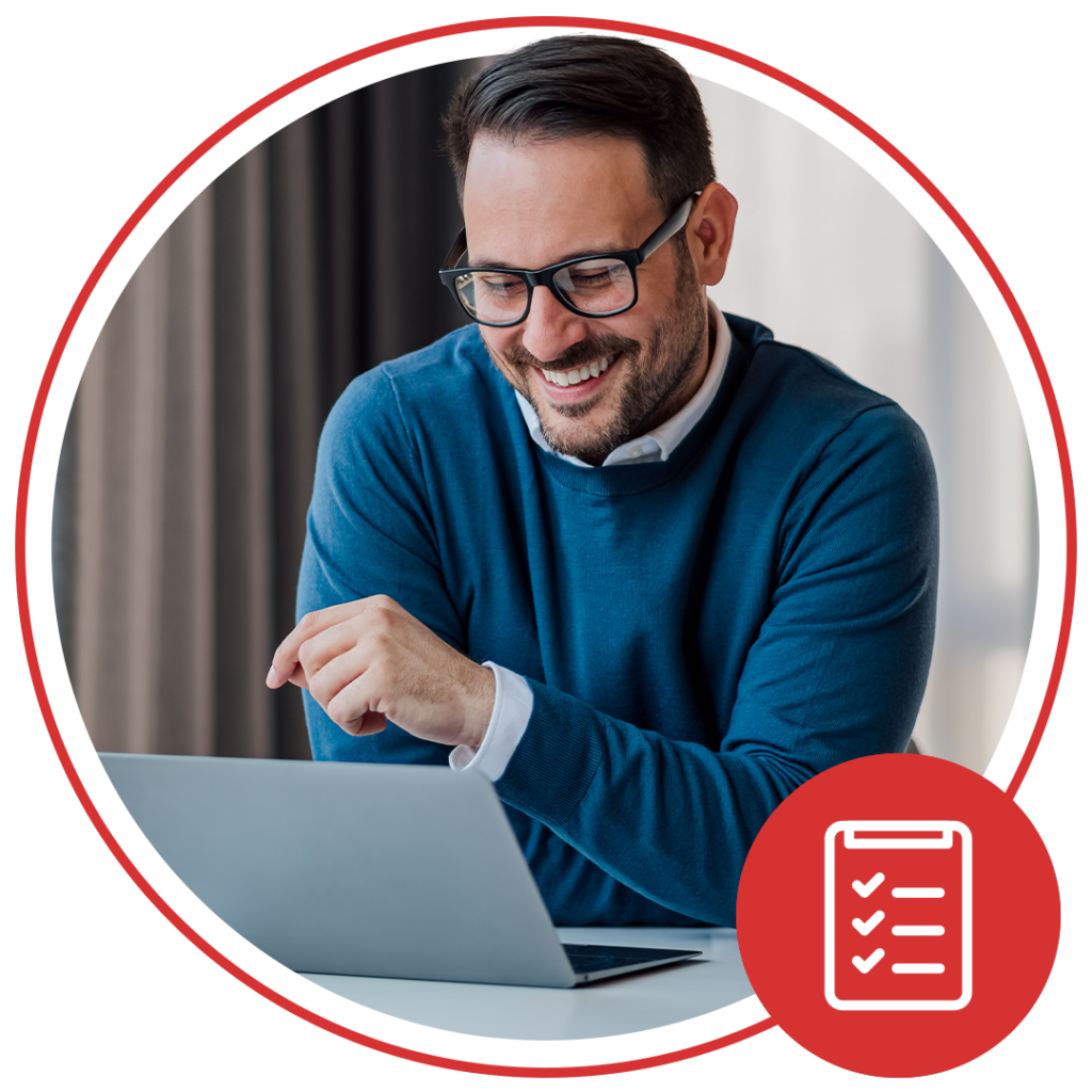 man smiling while using his laptop