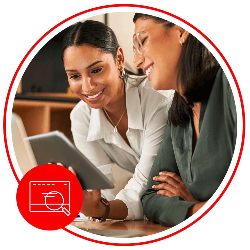 two woman looking at an ipad