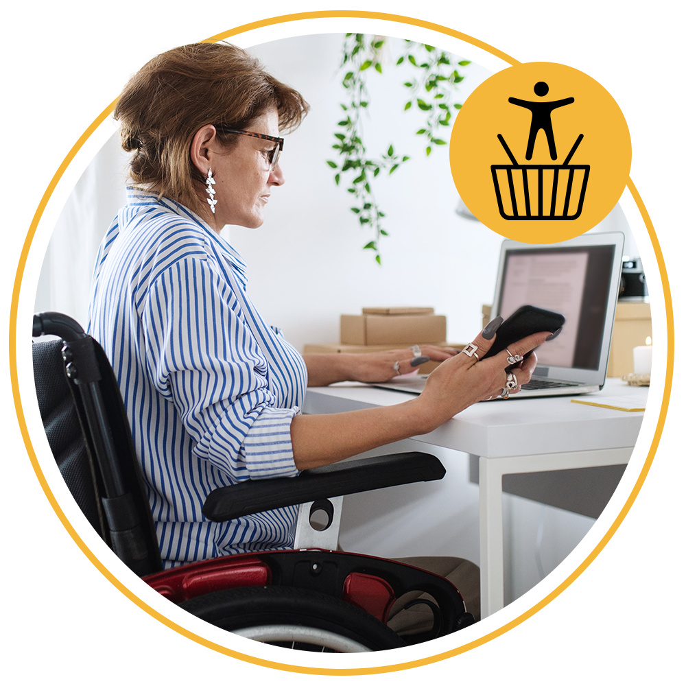 woman sitting at desk using phone and laptop
