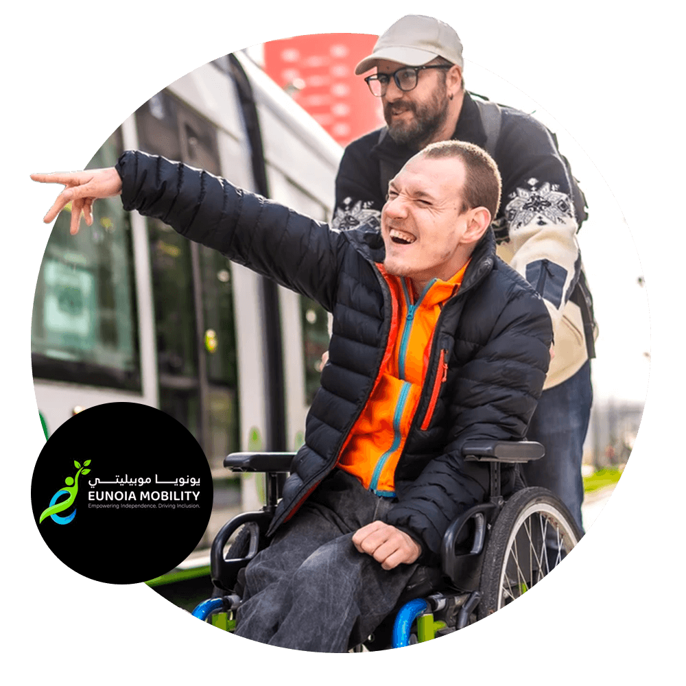 Image of a man in a wheelchair with another man standing behind him pushing the wheelchair