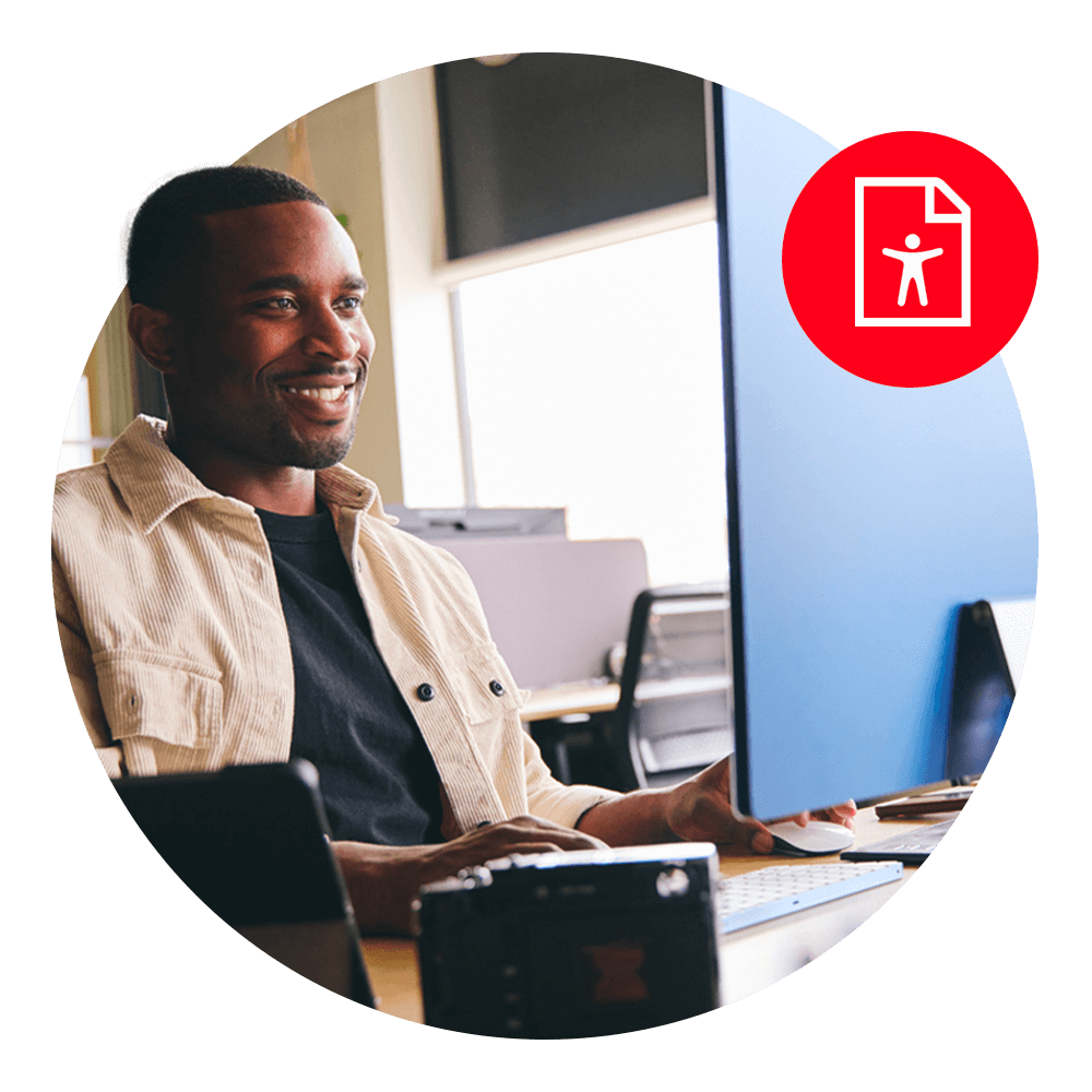 man sitting at computer monitor smiling