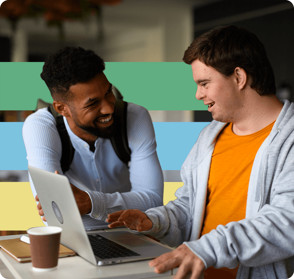 Carer and a man with down's syndrome laughing while browsing the web