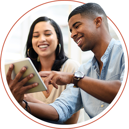 Two people looking at a tablet smiling