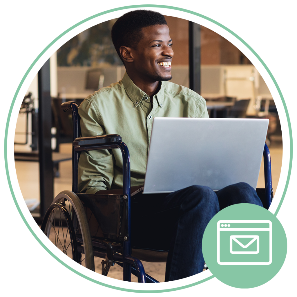 disabled person smiling while sitting in a wheelchair on a laptop