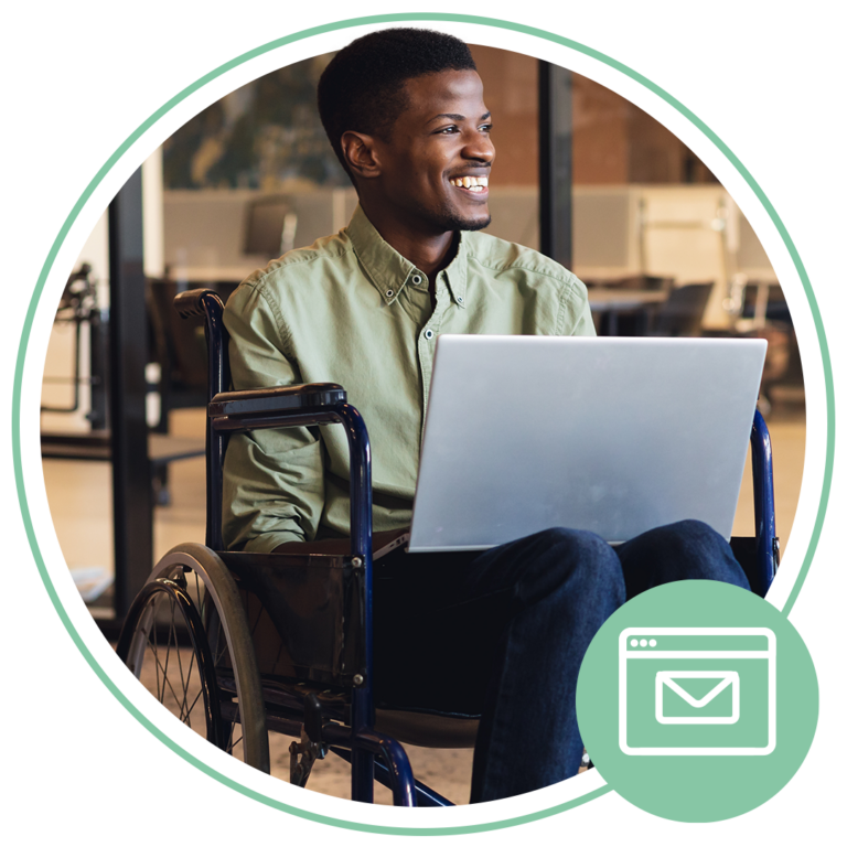 disabled person smiling while sitting in a wheelchair on a laptop