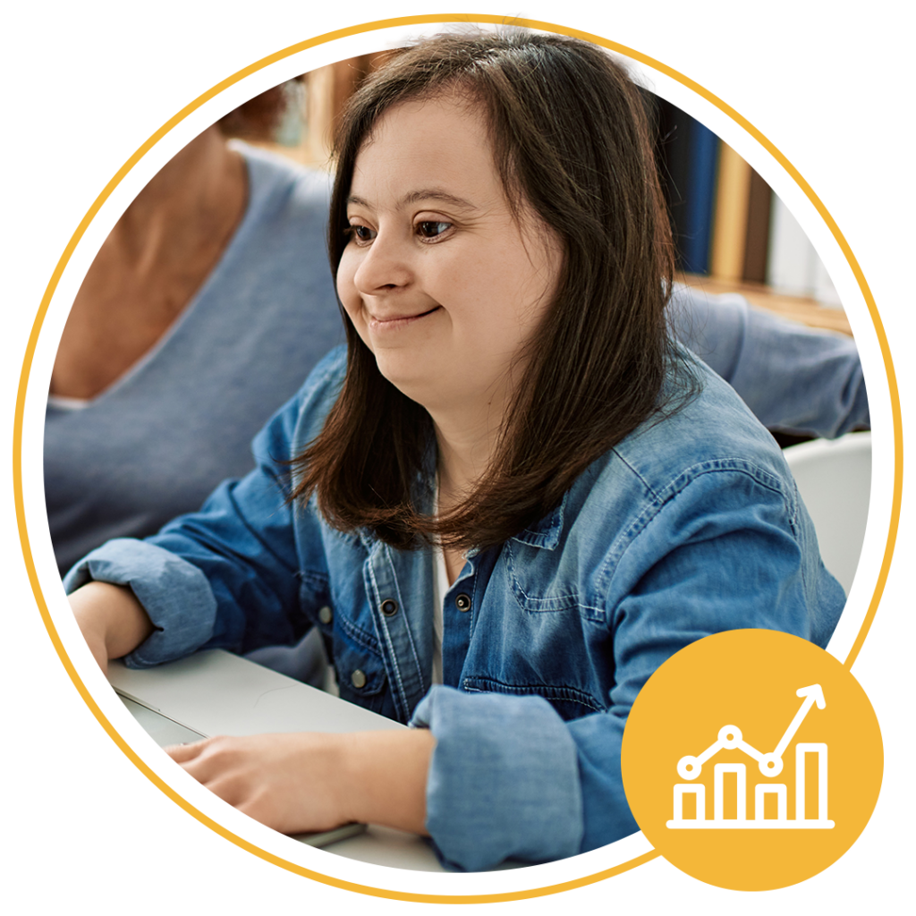 girl sitting down using a laptop and smiling