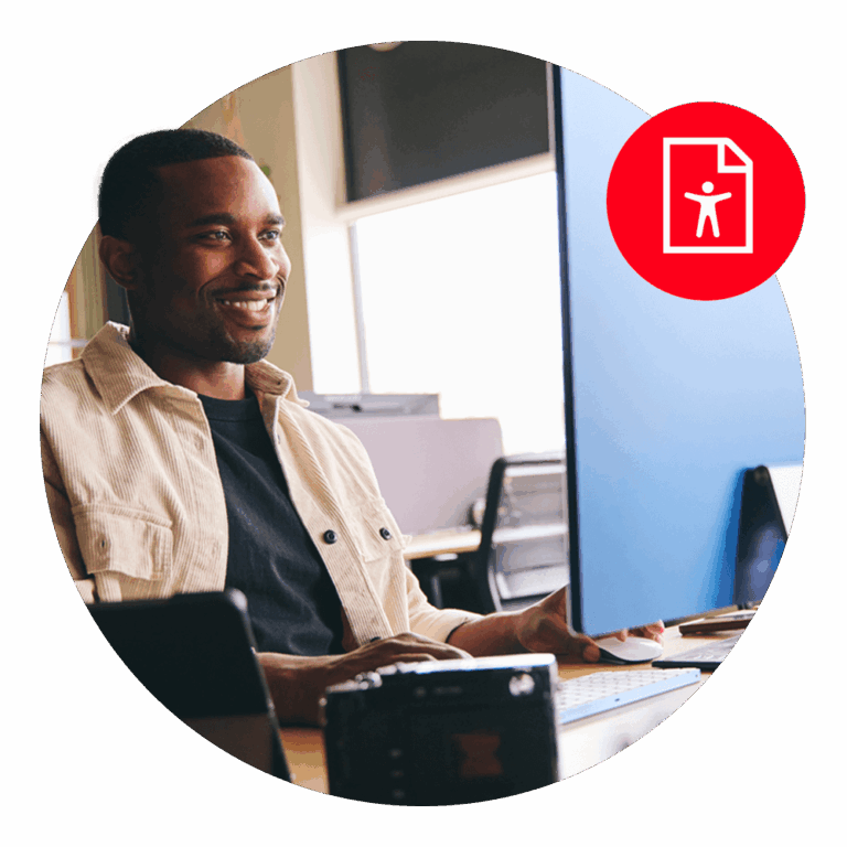 man sitting at computer monitor smiling